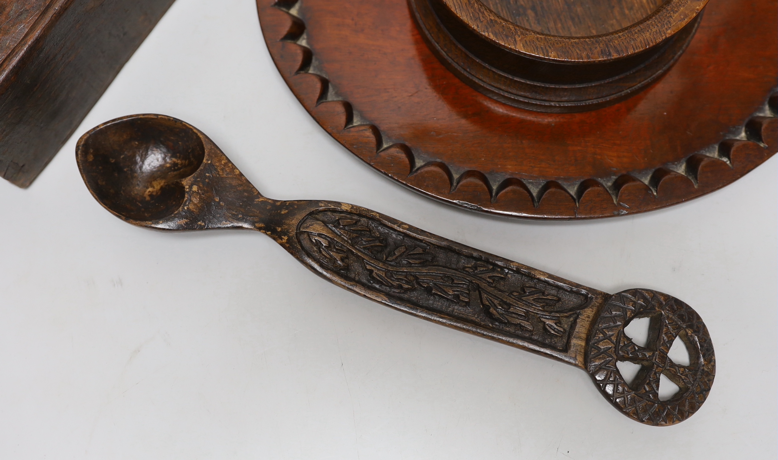 Treen including carved love spoon, four section box with incised decoration and a coaster, the largest 27cm wide